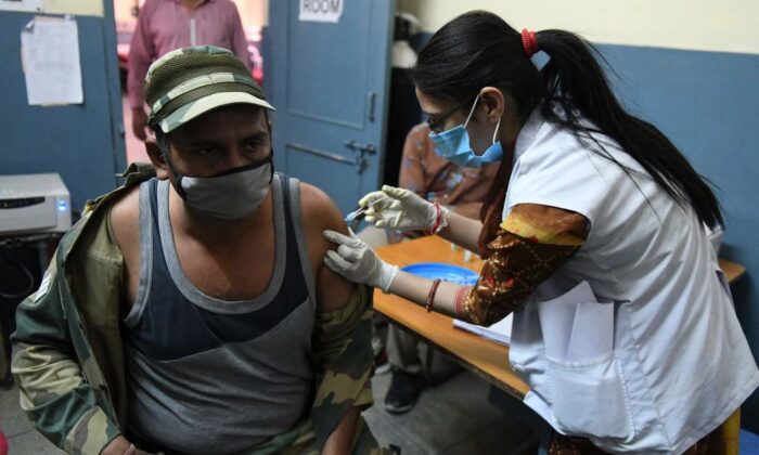 A medical worker inoculates a Border Security Force (BSF) personnel with a dose of the Covishield, ChAdOx1 nCoV-19 coronavirus vaccine, at a civil hospital in Ajnala village, about 28 km from Amritsar on April 1, 2021, as India expanded its coronavirus vaccination drive to the 45-60 age group. (Photo by NARINDER NANU / AFP) (Photo by NARINDER NANU/AFP via Getty Images)