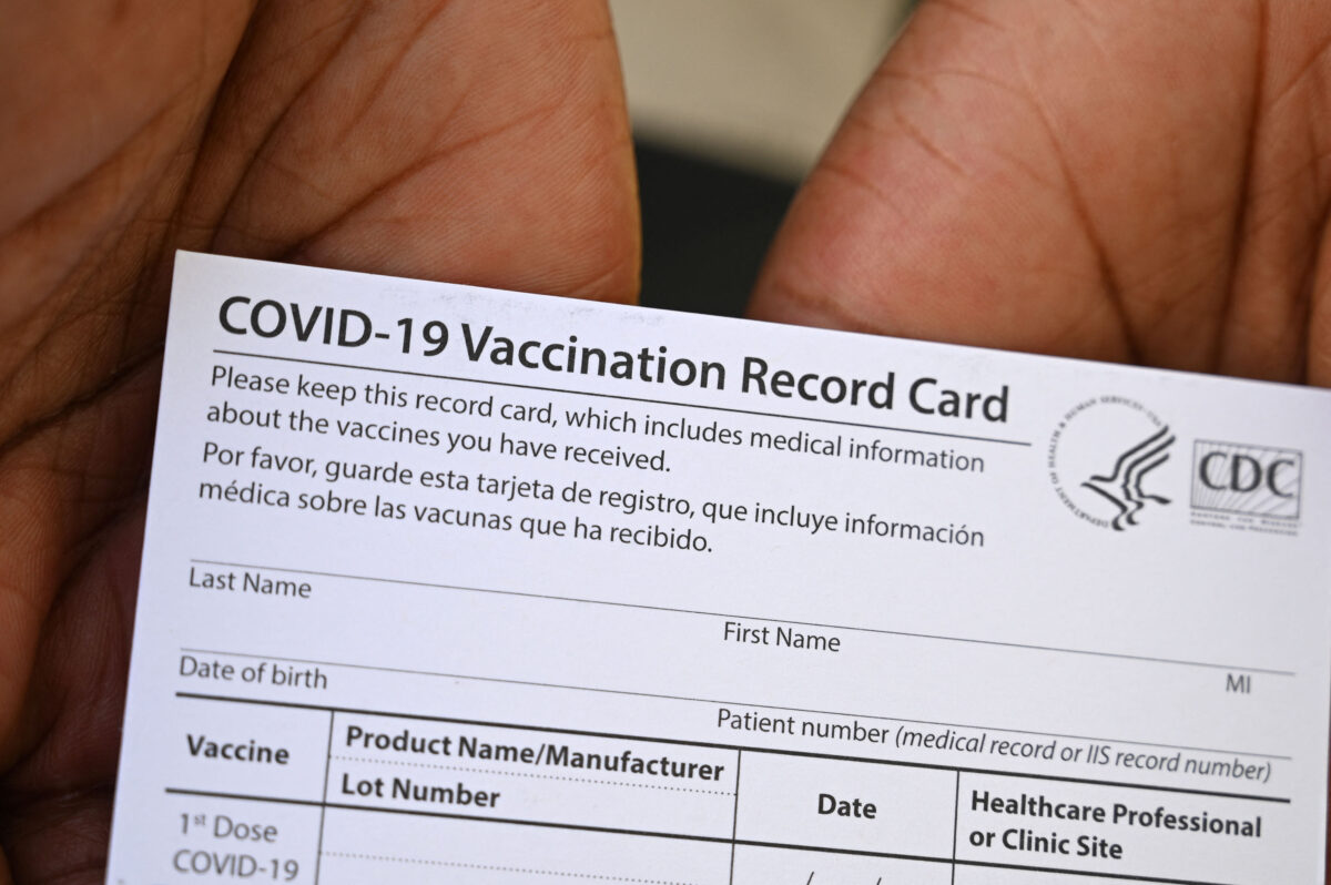 A healthcare worker displays a Covid-19 Vaccination Record Card during a vaccine and health clinic at QueensCare Health Center in a predominately Latino neighborhood in Los Angeles, California, August 11, 2021. - All teachers in California will have to be vaccinated against Covid-19 or submit to weekly virus tests, Governor Gavin Newsom announced on August 11, as authorities grapple with exploding infection rates. The number of people testing positive for the disease has surged in recent weeks, with the highly infectious Delta variant blamed for the bulk of new cases. (Photo by Robyn Beck / AFP) (Photo by ROBYN BECK/AFP via Getty Images)