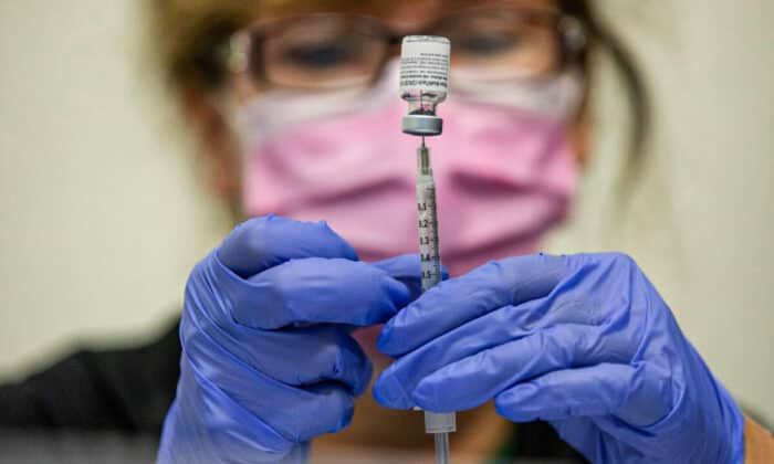 FILE PHOTO: A nurses fills up syringes for patients as they receive their coronavirus disease (COVID-19) booster vaccination during a Pfizer-BioNTech vaccination clinic in Southfield, Michigan, U.S., September 29, 2021.  REUTERS/Emily Elconin